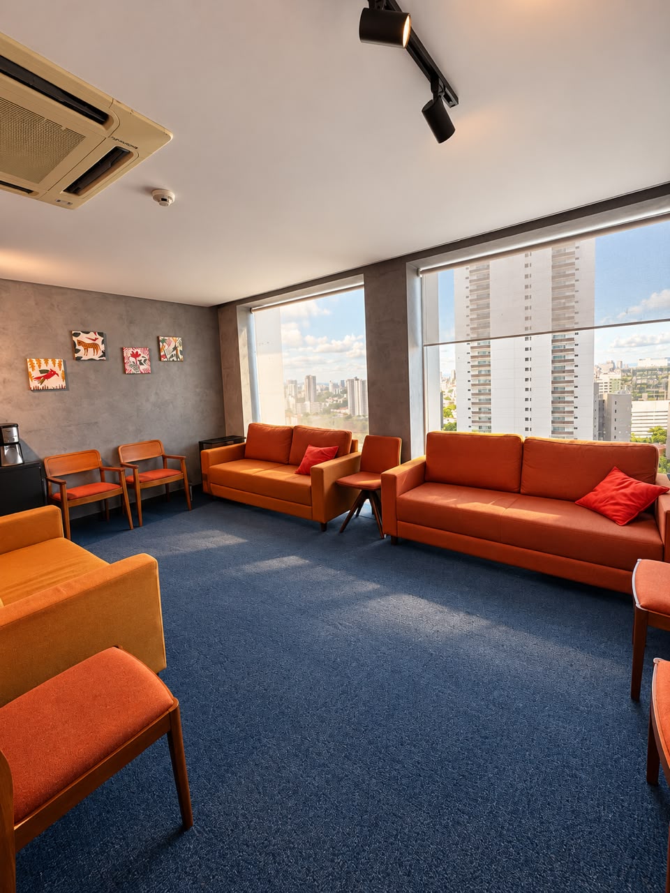 Sala de espera com sofás e janelas amplas